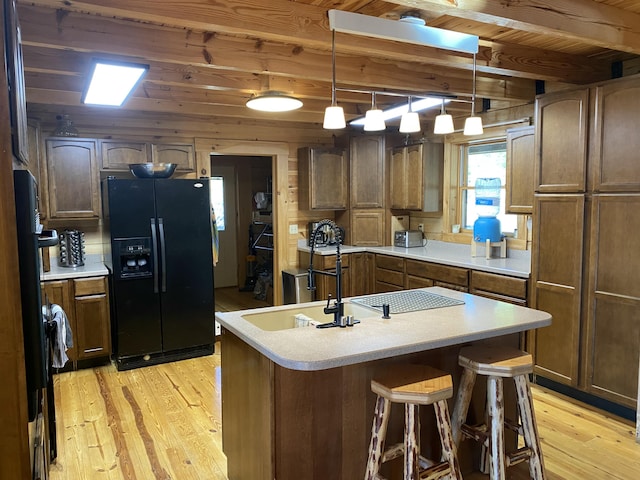 431 Harold Luke Rd, Campton, KY 41301 - kitchen featuring black refrigerator with ice dispenser, light wood finished floors, wooden ceiling with exposed beams, a sink, and a kitchen island with sink