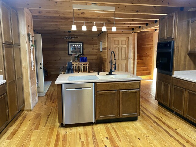 431 Harold Luke Rd, Campton, KY 41301 - kitchen featuring stainless steel dishwasher, a sink, oven, light wood-style floors, and wood walls