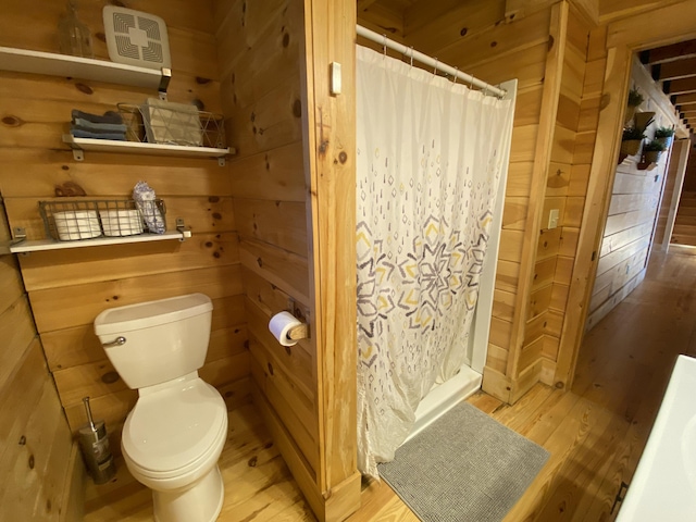 431 Harold Luke Rd, Campton, KY 41301 - bathroom with wood finished floors, toilet, a shower with curtain, and wooden walls