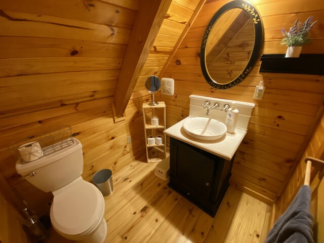 431 Harold Luke Rd, Campton, KY 41301 - half bathroom with wood-type flooring, wooden walls, vanity, and toilet