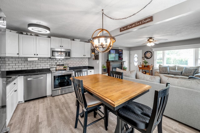 208 Westmoreland Ct, Georgetown, KY 40324 - dining area featuring ceiling fan, light wood finished floors, a chandelier, and a textured ceiling