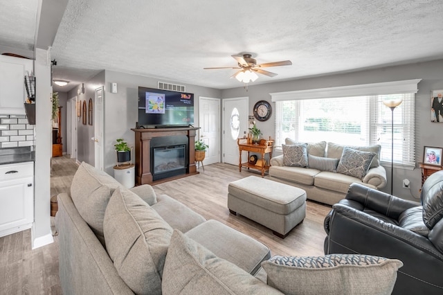 208 Westmoreland Ct, Georgetown, KY 40324 - living room featuring ceiling fan, a textured ceiling, light wood finished floors, and a glass covered fireplace