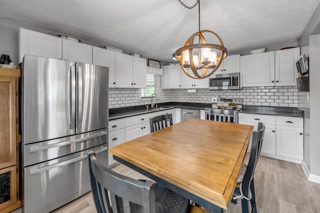 208 Westmoreland Ct, Georgetown, KY 40324 - kitchen featuring appliances with stainless steel finishes, a chandelier, dark countertops, a sink, and backsplash