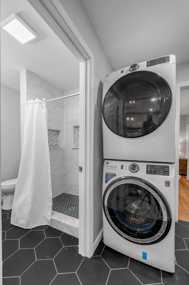 1626 Raleigh Rd, Lexington, KY 40505 - laundry room featuring stacked washing machine and dryer and dark tile patterned flooring