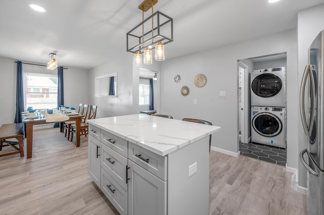 1626 Raleigh Rd, Lexington, KY 40505 - kitchen featuring stacked washer and clothes dryer, healthy amount of natural light, a kitchen island, and light wood finished floors