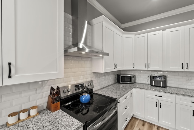 559 Breckenridge St, Lexington, KY 40508 - kitchen featuring stainless steel appliances, wall chimney range hood, crown molding, white cabinetry, and decorative backsplash