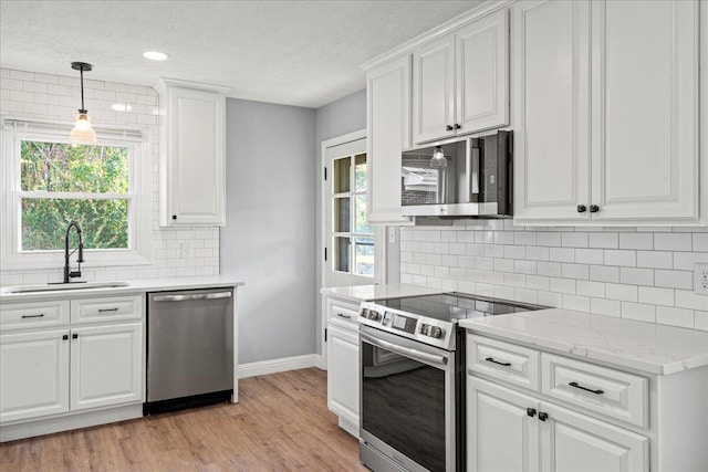 113 Buckwood Dr, Richmond, KY 40475 - kitchen featuring stainless steel appliances, a sink, baseboards, light wood-type flooring, and a textured ceiling