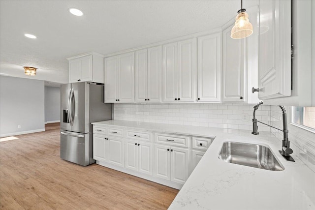 113 Buckwood Dr, Richmond, KY 40475 - kitchen featuring a sink, stainless steel fridge, white cabinets, tasteful backsplash, and hanging light fixtures