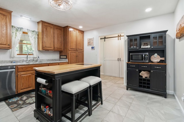 21 Vicki St, Nancy, KY 42544 - kitchen featuring appliances with stainless steel finishes, a barn door, a sink, wood counters, and brown cabinetry