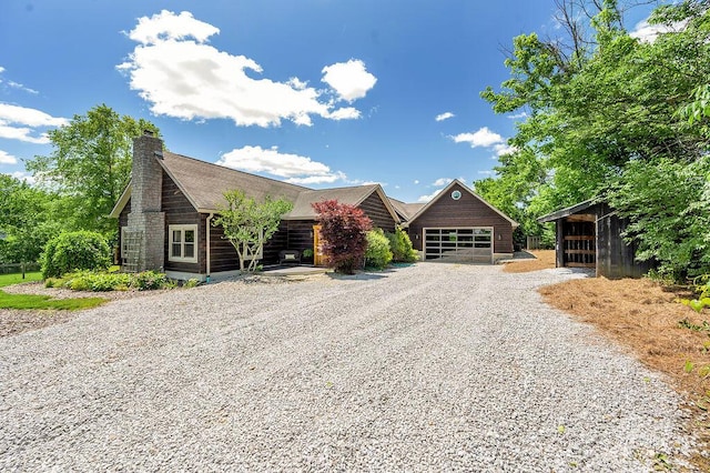 372 Sussex Ln, Nicholasville, KY 40356 - view of front of house with driveway, a chimney, a garage, an outdoor structure, and a pole building