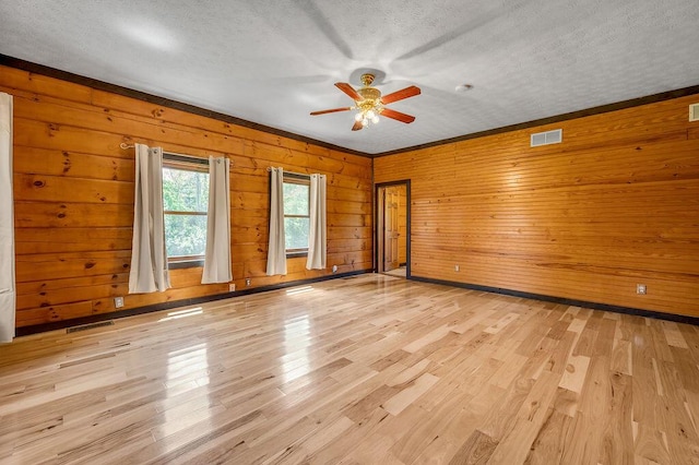 372 Sussex Ln, Nicholasville, KY 40356 - empty room with ceiling fan, a textured ceiling, wooden walls, and light wood-type flooring