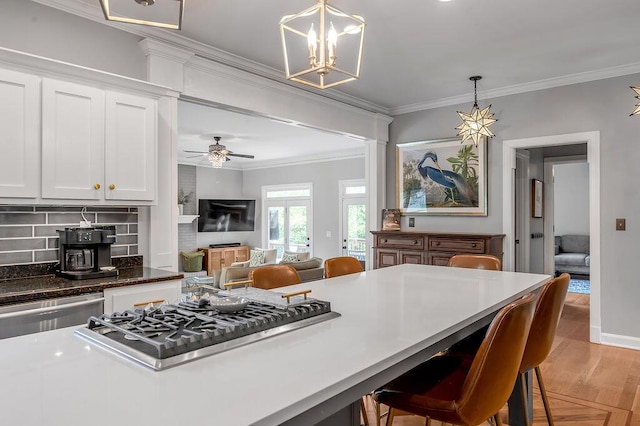 2245 Abbeywood Rd, Lexington, KY 40515 - kitchen with stainless steel appliances, crown molding, white cabinets, hanging light fixtures, and a kitchen bar