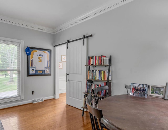 2245 Abbeywood Rd, Lexington, KY 40515 - dining area featuring crown molding, a barn door, wood finished floors, and baseboards