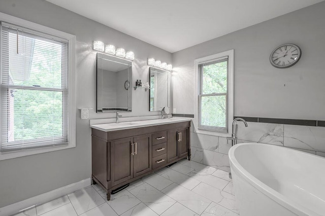 2245 Abbeywood Rd, Lexington, KY 40515 - bathroom with a soaking tub, double vanity, marble look tile flooring, wainscoting, and tile walls