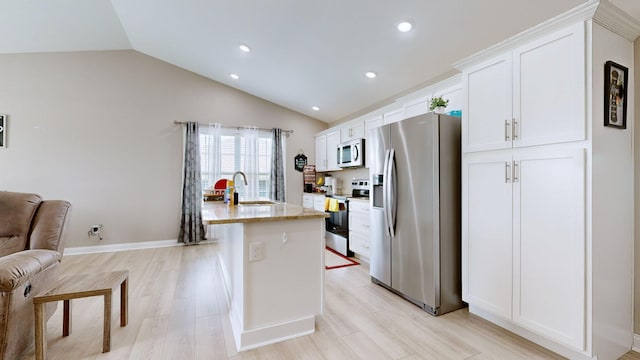 345 Memory Ln, Richmond, KY 40475 - kitchen featuring appliances with stainless steel finishes, a sink, white cabinetry, an island with sink, and lofted ceiling
