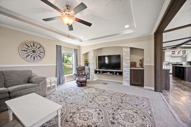 5483 US Highway 150 E, Stanford, KY 40484 - living area featuring a raised ceiling, ornamental molding, arched walkways, ceiling fan, and a textured ceiling