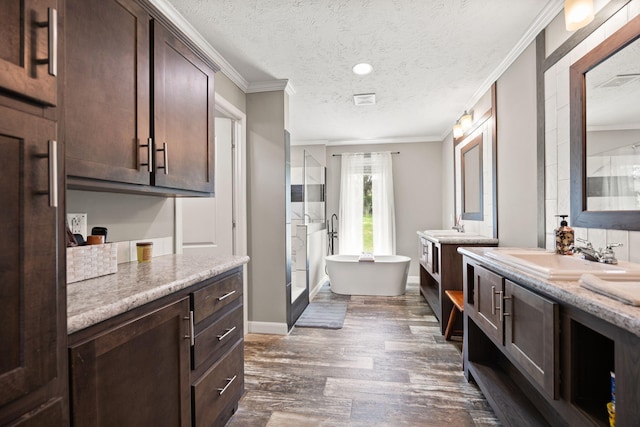 5483 US Highway 150 E, Stanford, KY 40484 - bathroom with ornamental molding, two vanities, a freestanding tub, wood finished floors, and a textured ceiling