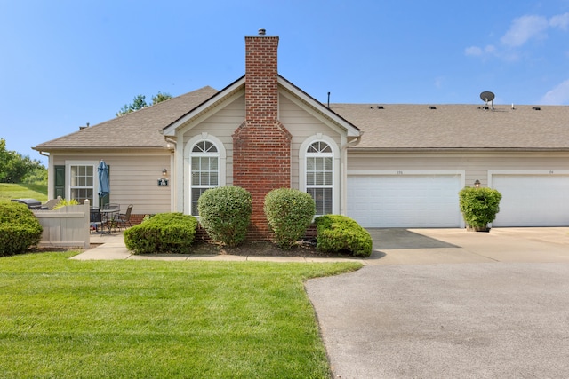 196 Academy Dr, Wilmore, KY 40390 - view of front of house featuring driveway, a front yard, a chimney, an attached garage, and a shingled roof