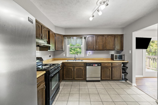 263 S Eagle Creek Dr, Lexington, KY 40515 - kitchen with stainless steel appliances, under cabinet range hood, a sink, light countertops, and dark brown cabinetry