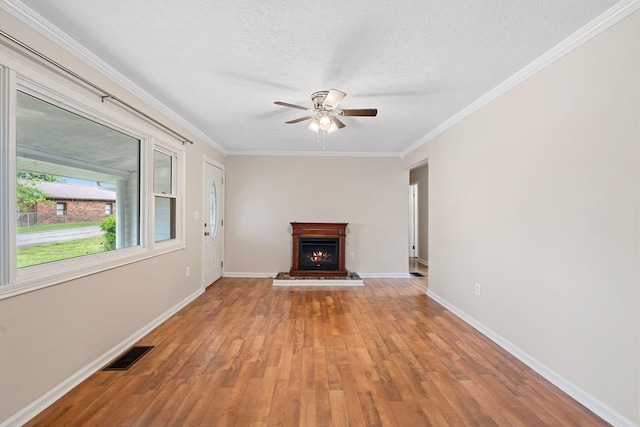 1780 Ballard Rd, Lawrenceburg, KY 40342 - unfurnished living room with ceiling fan, a warm lit fireplace, light wood finished floors, crown molding, and a textured ceiling