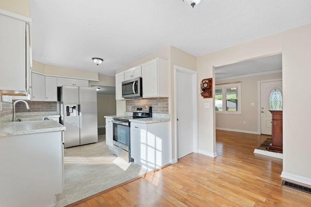 1780 Ballard Rd, Lawrenceburg, KY 40342 - kitchen with appliances with stainless steel finishes, light countertops, tasteful backsplash, light wood finished floors, and white cabinetry