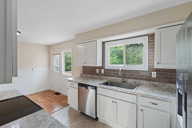 1780 Ballard Rd, Lawrenceburg, KY 40342 - kitchen featuring dishwasher, wainscoting, light wood-type flooring, light countertops, and white cabinetry