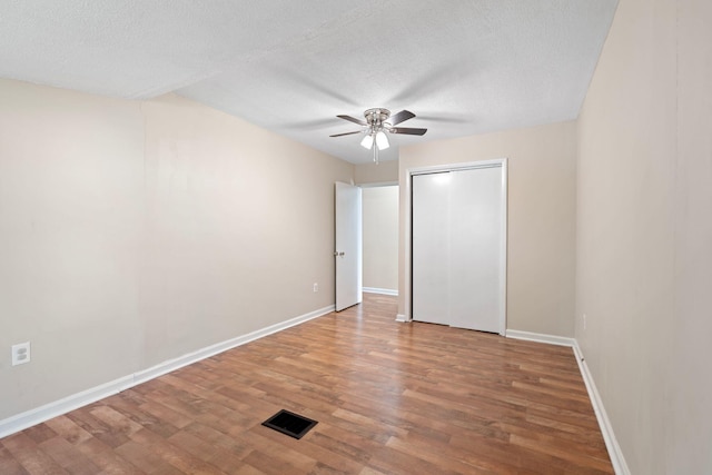 1780 Ballard Rd, Lawrenceburg, KY 40342 - unfurnished bedroom with wood finished floors, a textured ceiling, a ceiling fan, and a closet