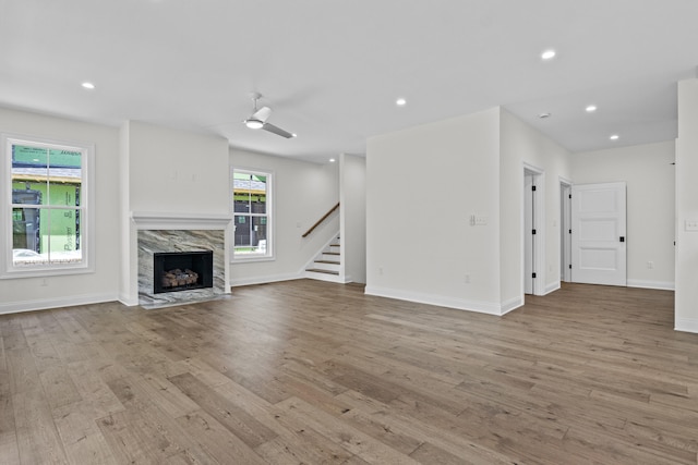 3521 Harper Woods Ln, Lexington, KY 40515 - unfurnished living room featuring wood finished floors, stairway, a high end fireplace, a ceiling fan, and recessed lighting