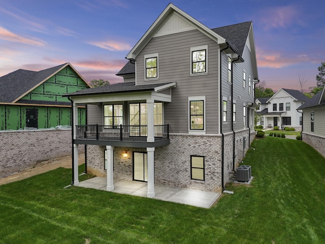 3521 Harper Woods Ln, Lexington, KY 40515 - back of property with a patio area, a yard, brick siding, central AC, and a balcony