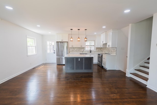 1613 Hastings Ct, Lexington, KY 40505 - kitchen with stainless steel appliances, a center island, backsplash, white cabinetry, and plenty of natural light