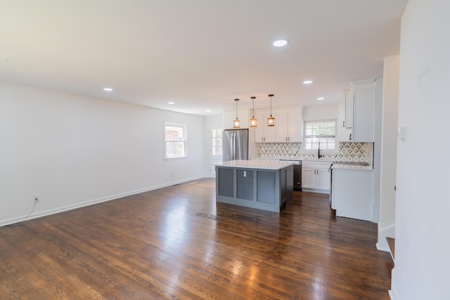 1613 Hastings Ct, Lexington, KY 40505 - kitchen with stainless steel appliances, a kitchen island, white cabinets, decorative backsplash, and pendant lighting