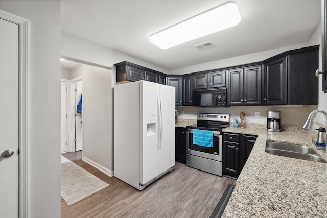 1748 Chandler Ln, Lexington, KY 40504 - kitchen with white refrigerator with ice dispenser, stainless steel range with electric cooktop, black microwave, a sink, and light wood-type flooring
