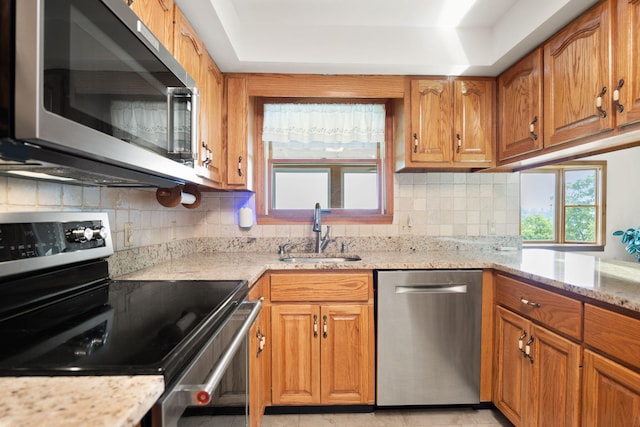 1636 Green Hill Estates Rd, Monticello, KY 42633 - kitchen featuring appliances with stainless steel finishes, a sink, brown cabinetry, and decorative backsplash