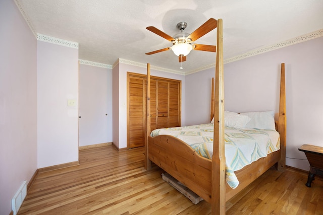1636 Green Hill Estates Rd, Monticello, KY 42633 - bedroom featuring crown molding, light wood-style floors, baseboards, a ceiling fan, and a closet