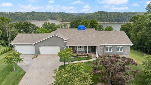 1636 Green Hill Estates Rd, Monticello, KY 42633 - ranch-style home with concrete driveway, a wooded view, a garage, a water view, and a porch