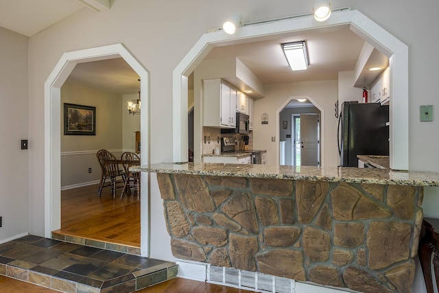 301 Atwood Dr, Lexington, KY 40515 - kitchen with black appliances, white cabinets, light stone countertops, dark wood-style floors, and baseboards