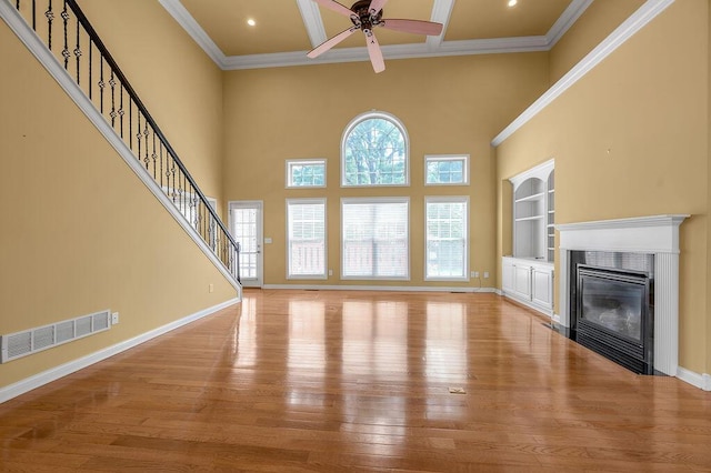 3765 Ridge View Way, Lexington, KY 40509 - unfurnished living room with ceiling fan, light wood-style floors, crown molding, built in shelves, and a glass covered fireplace