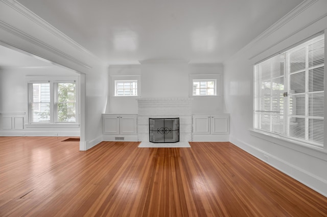 109 N Ashland Ave, Lexington, KY 40502 - unfurnished living room featuring a brick fireplace, wood finished floors, and ornamental molding