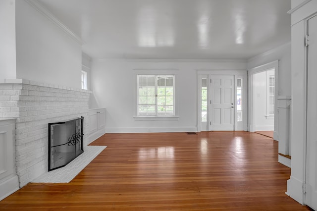109 N Ashland Ave, Lexington, KY 40502 - unfurnished living room with a brick fireplace, ornamental molding, hardwood / wood-style flooring, and baseboards