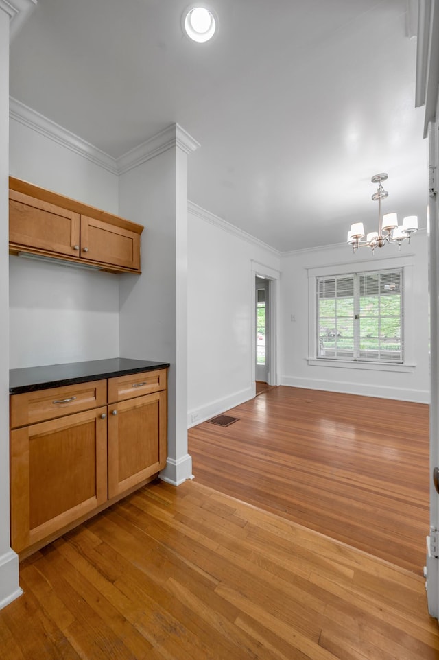 109 N Ashland Ave, Lexington, KY 40502 - kitchen with a chandelier, light wood-type flooring, dark countertops, baseboards, and ornamental molding