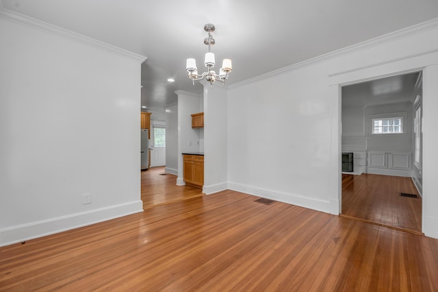 109 N Ashland Ave, Lexington, KY 40502 - spare room with a chandelier, light wood finished floors, ornamental molding, plenty of natural light, and a fireplace