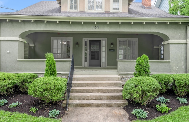 109 N Ashland Ave, Lexington, KY 40502 - entrance to property featuring stucco siding, covered porch, a chimney, and a shingled roof