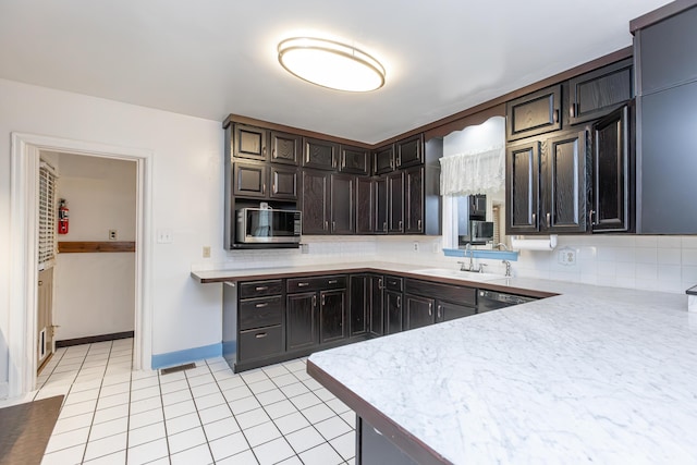 645 Raven Dr, Frankfort, KY 40601 - kitchen featuring stainless steel microwave, a sink, backsplash, light countertops, and dark brown cabinetry