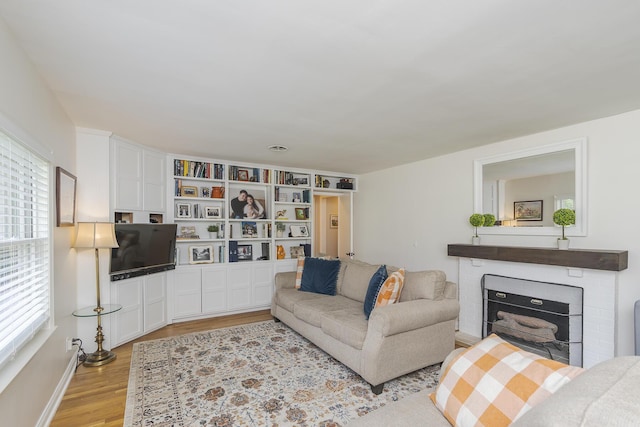 235 W Vista St, Lexington, KY 40503 - living room featuring light wood finished floors, a brick fireplace, and baseboards