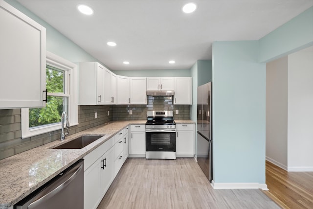 289 Mulberry Ct, Lexington, KY 40509 - kitchen featuring stainless steel appliances, a sink, under cabinet range hood, light stone countertops, and white cabinets