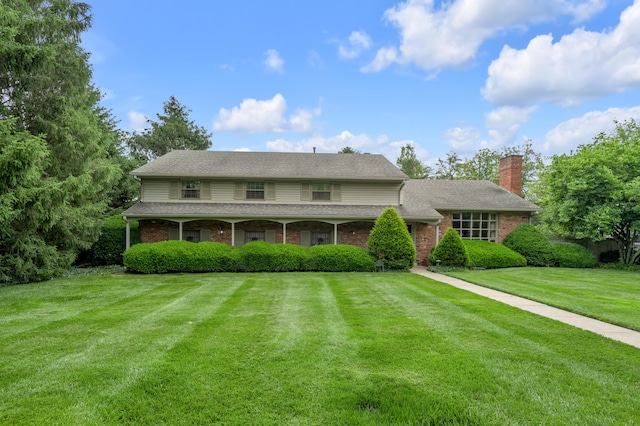 754 Chinoe Rd, Lexington, KY 40502 - view of front facade with a chimney, brick siding, a front yard, and a shingled roof