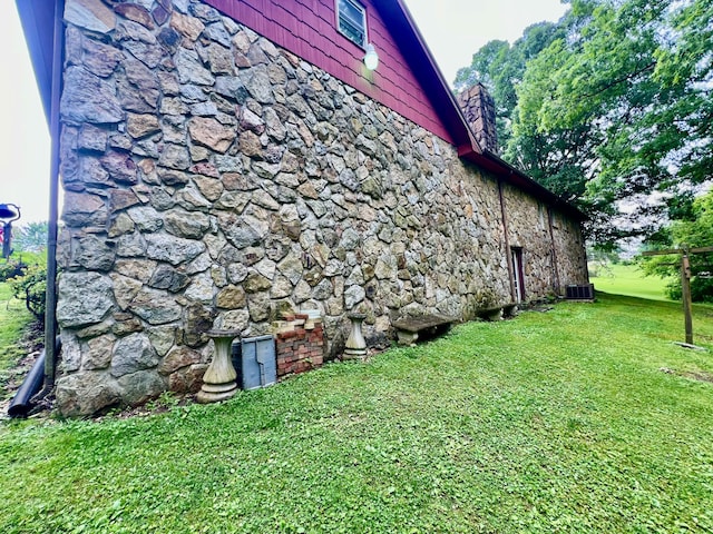 2369 Big Cave Rd, Mount Vernon, KY 40456 - view of side of home with stone siding, a chimney, a yard, and central air condition unit