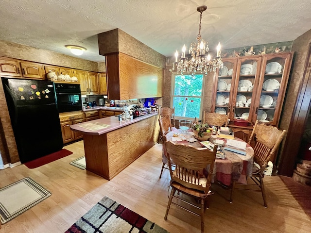 2369 Big Cave Rd, Mount Vernon, KY 40456 - dining space featuring a chandelier, light wood-type flooring, and a textured ceiling