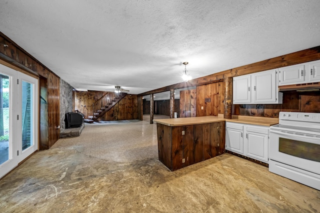 399 Stonecrest Rd, Winchester, KY 40391 - kitchen featuring white range with electric cooktop, wood walls, under cabinet range hood, a textured ceiling, and a peninsula