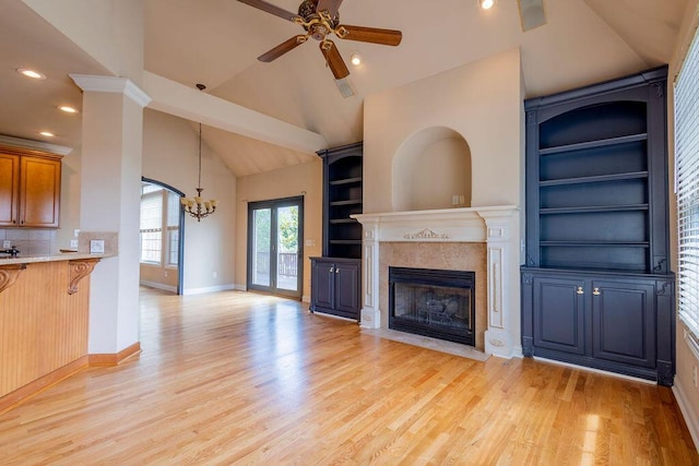 2433 San Milano Pl, Lexington, KY 40509 - unfurnished living room featuring vaulted ceiling, light wood-type flooring, a chandelier, a fireplace, and ceiling fan